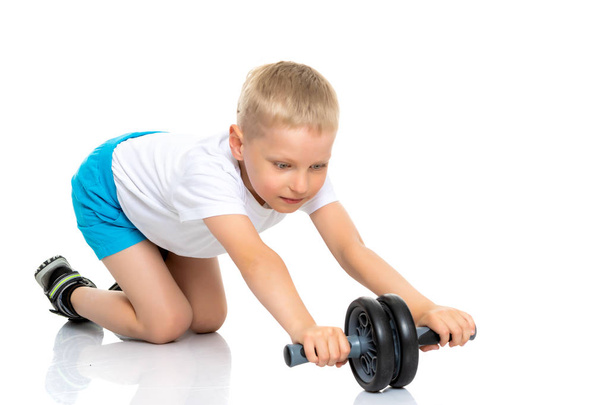 A little boy in a clean white T-shirt is engaged in fitness. - Photo, image