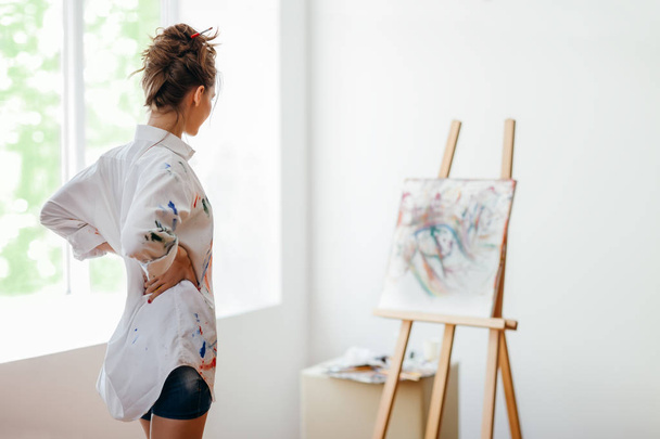 Artista donna che analizza la pittura in studio d'arte
 - Foto, immagini