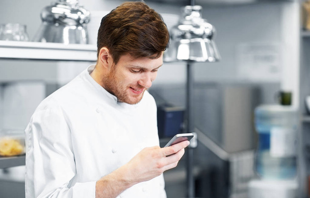 chef cook with smartphone at restaurant kitchen - Zdjęcie, obraz