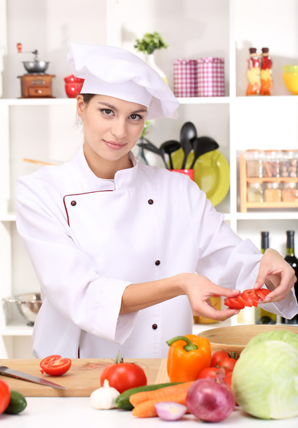 Young woman chef cooking in kitchen - Foto, afbeelding