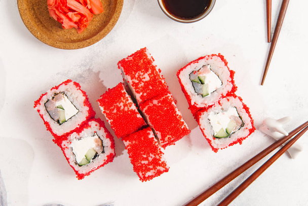 Vista superior de los tradicionales rollos de sushi japoneses servidos con jengibre sobre fondo de piedra blanca
 - Foto, imagen