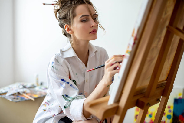 Closeup of woman painting on canvas in studio. Creative concept - Фото, зображення