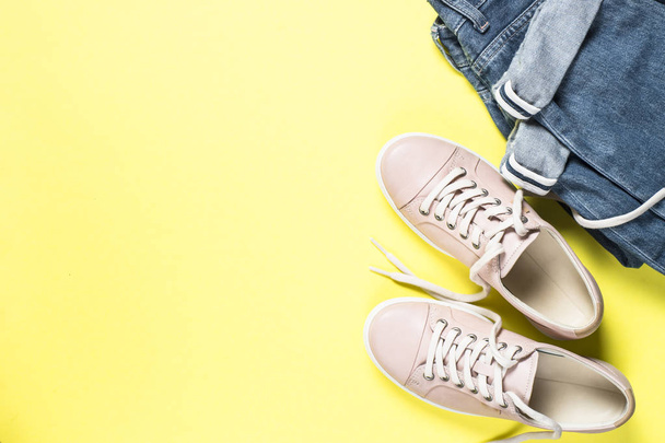 Damenmode rosa Schuhe und Jeans auf gelbem Oberteil. - Foto, Bild
