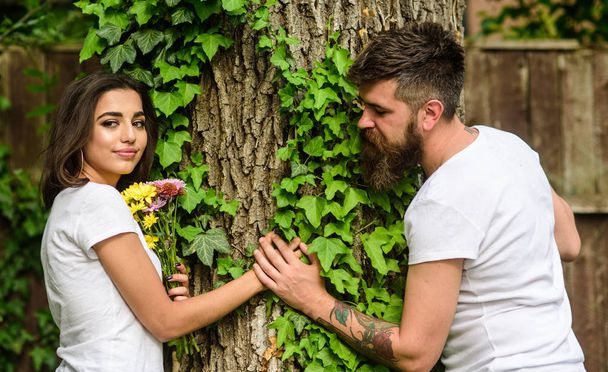 Man bearded hipster holds hand girlfriend. Couple in love romantic date walk nature tree background. Love relations romantic feelings. Park best place for romantic date. Enjoy romantic date in park - Фото, изображение