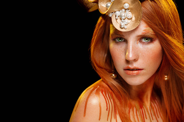 Schoonheid Fashion model meisje met gouden make-up, goud huid make-up, haar en juwelen op zwarte achtergrond. - Foto, afbeelding