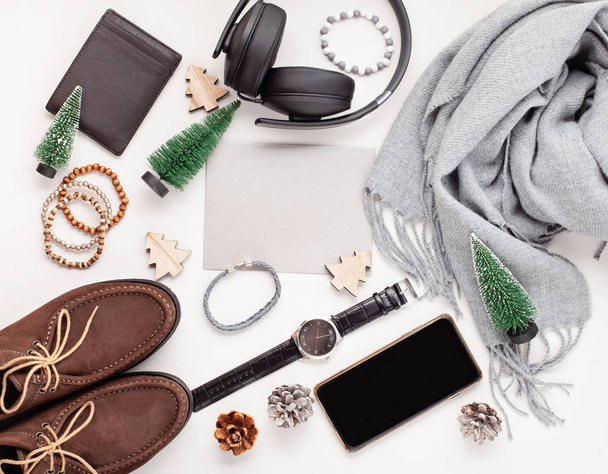 Plat leggen van mannen accessoires met schoenen, horloge, telefoon, koptelefoon, zonnebril, sjaal over de oranje achtergrond. Verkoop, winkelen, geschenkideeën. Bovenaanzicht - Foto, afbeelding
