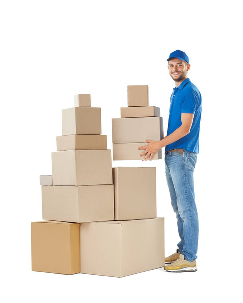 Full length portrait of delivery man holding stack of boxes isolated on white background - Zdjęcie, obraz