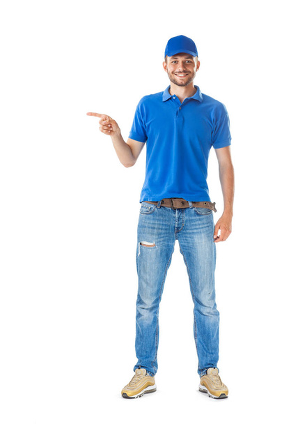 Full length portrait of handsome man in blue uniform pointing to right isolated on white background - Photo, Image