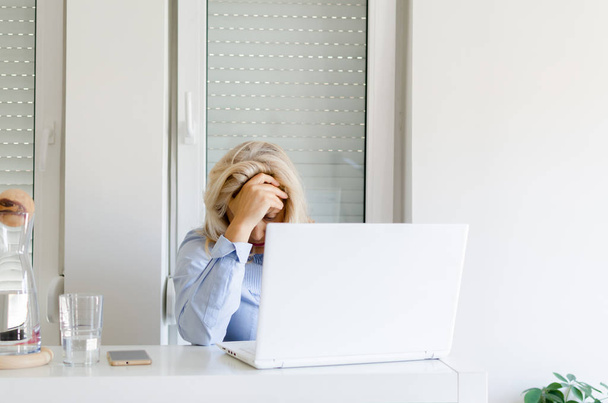 Senior woman feeling tired while working at home on laptop. - Photo, Image