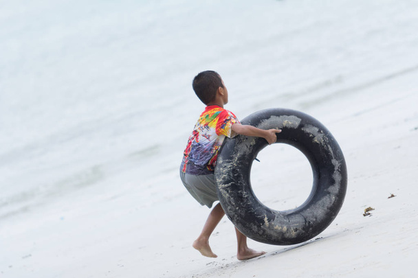 enfants garçon jouer avec la vie anneau sur la plage
 - Photo, image