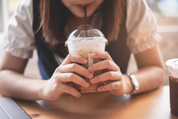 piękna dziewczyna trzymając lód kawę w kawiarni - Zdjęcie, obraz