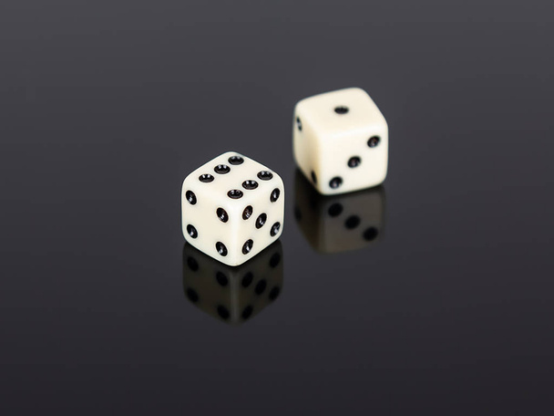 Due dadi di gioco bianchi su nero uno sfondo
 - Foto, immagini