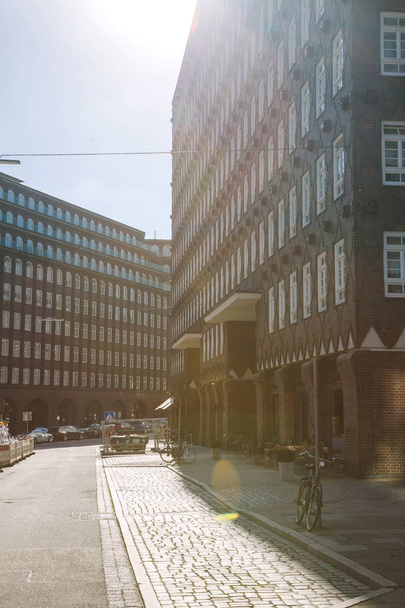 HAMBURG, GERMANY - 28 JUNE 2018: bicycles on street with sunlight, people sitting in cafes - Φωτογραφία, εικόνα