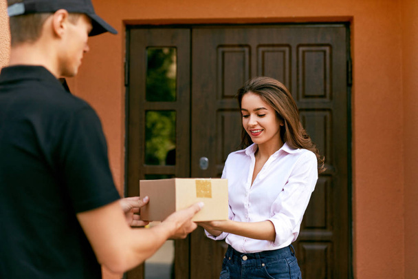 Express Delivery Service. Courier Delivering Package To Woman - Foto, Imagen