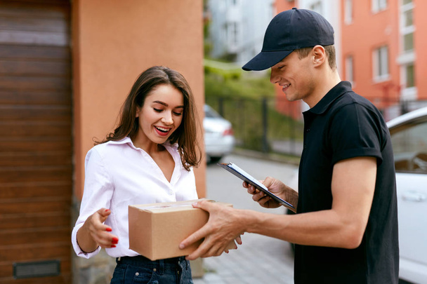 Express Delivery Service. Courier Delivering Package To Woman - Zdjęcie, obraz