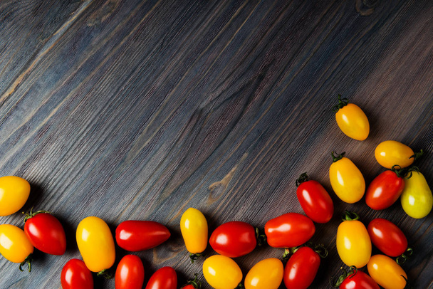 colorful ripe tomatoes on wooden table with copy space  - 写真・画像
