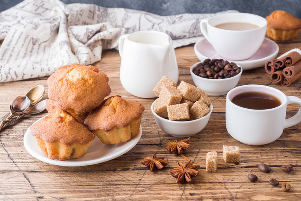 Snídaně a káva pro dvě osoby, pečivo, hnědý cukr a skořice s anýzu na dřevěné pozadí - Fotografie, Obrázek