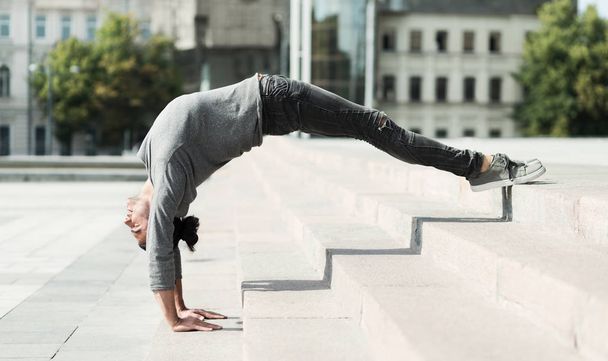 Man doing advanced yoga asana outdoors, side view - Φωτογραφία, εικόνα