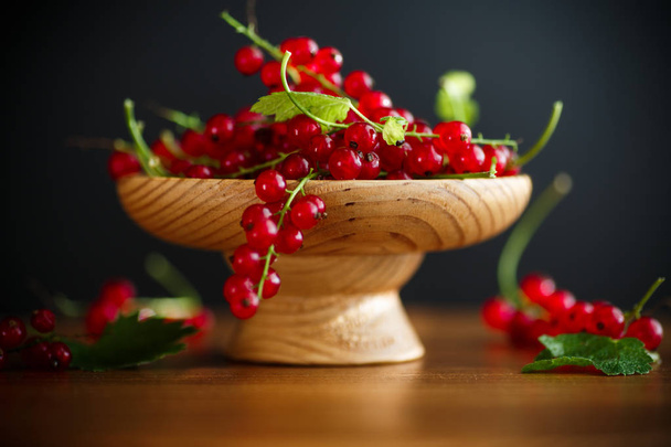 ripe berries natural red currants on a wooden table - Foto, afbeelding