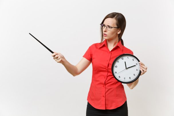 Young smart business teacher woman in red shirt glasses holding round clock, wooden classroom pointer on copy space isolated on white background. Education teaching in high school university concept - Photo, Image