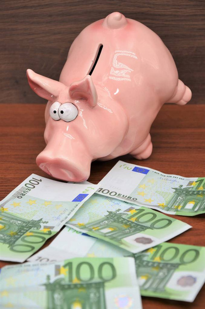 100 euro-bankbiljetten met grappige piggy bank - Foto, afbeelding