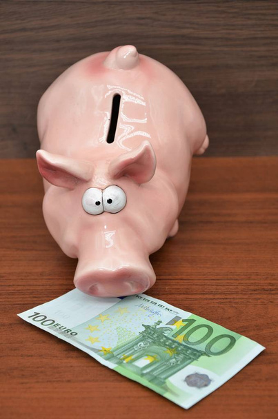 Nota de 100 euros com banco porquinho
 - Foto, Imagem