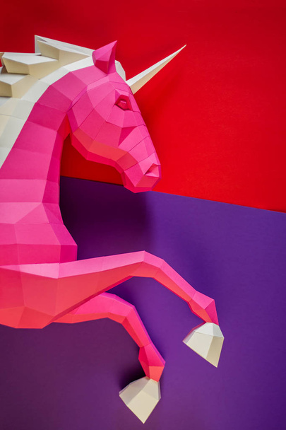 Head of a unicorn of paper on a pink and blue background. - Fotoğraf, Görsel