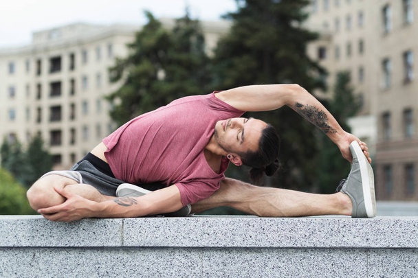 Hombre haciendo ejercicio de estiramiento de yoga en la ciudad
 - Foto, imagen