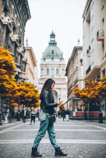 donna attraversando strada in budapest vecchia chiesa nel centro. L'autunno sta arrivando. viaggi in città
 - Foto, immagini