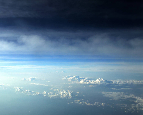 πτήση σε ένα αεροπλάνο πάνω από τα σύννεφα, η θέα από το εσωτερικό του, στον ορίζοντα, η γραμμή του ουρανού - Φωτογραφία, εικόνα