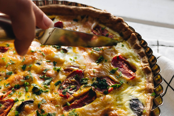 maschio taglio a mano deliziosa pizza con formaggio, pomodori ed erbe aromatiche, cucina tradizionale italiana
  - Foto, immagini