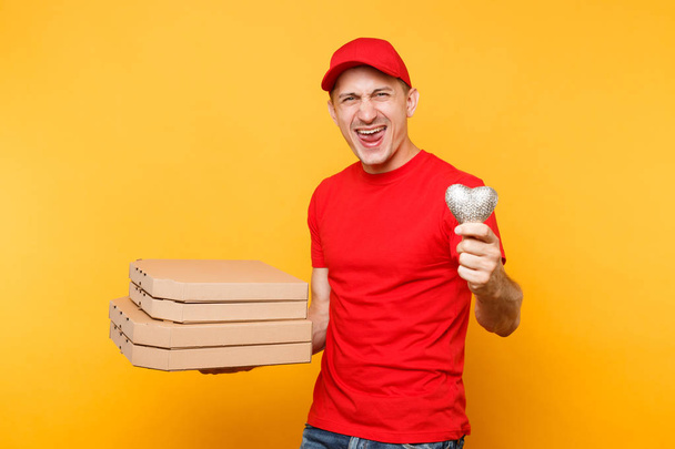 配達人はキャップ t シャツ黄色の背景に分離されて与える食品注文のピザ箱です。段ボール flatbox の中心のイタリアのピザを保持している制服を着た男性従業員 pizzaman 宅配便。サービスのコンセプト - 写真・画像