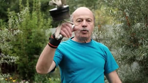 Senior caucasian man training arms doing special exercise with weight. - Video, Çekim