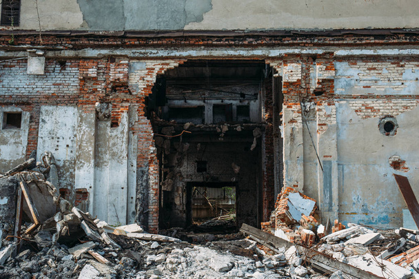 Разрушенное заброшенное промышленное здание с большими таблетками бетонного мусора, последствия стихийного бедствия, урагана, землетрясения или войны, тонизированные
   - Фото, изображение