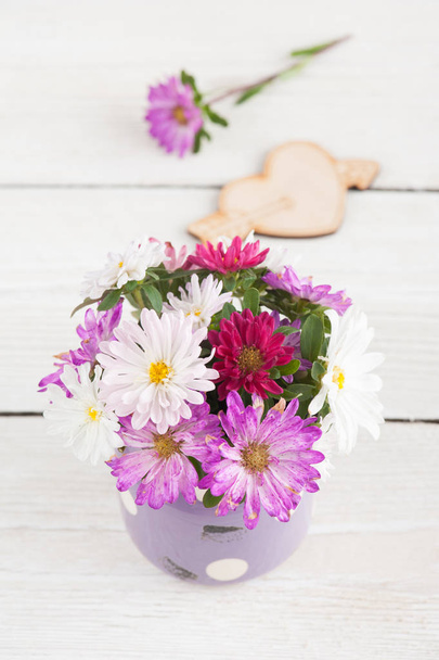 Pink purple garden flowers in old pot on wooden backgrounds - Photo, Image