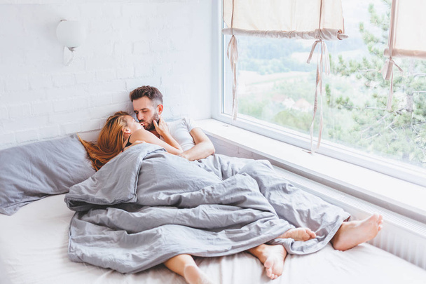 Young couple enjoying bed time in the morning - Fotoğraf, Görsel