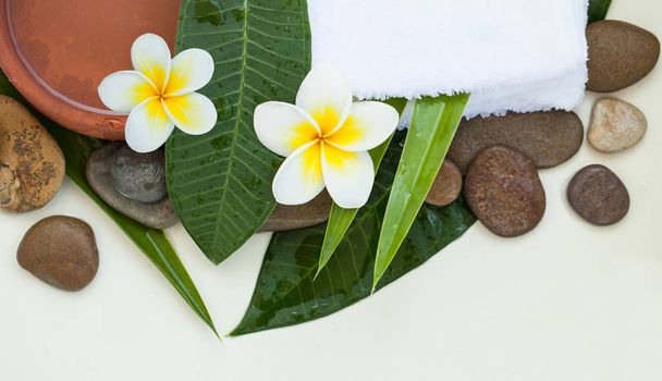 Top view Spa or wellness background with white towels, tropical leaves, flowers - Photo, Image