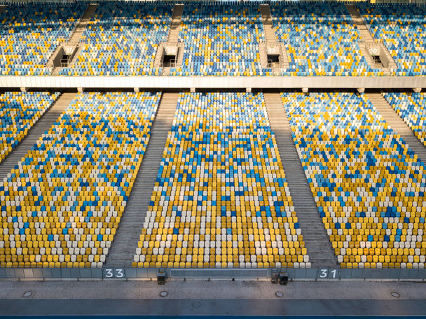 KIEV, UKRAINE - July 19, 2018. Panoramic view from drone on empty even rows tribunes of National Sports Complex Olimpiysky in a blue and yellow colors in the summer time. - Foto, Imagen