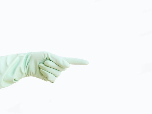 Handen in een economische handschoen van rode kleur voor huishoudelijke chemie zijn geïsoleerd op een gekleurde achtergrond voor een design - Foto, afbeelding