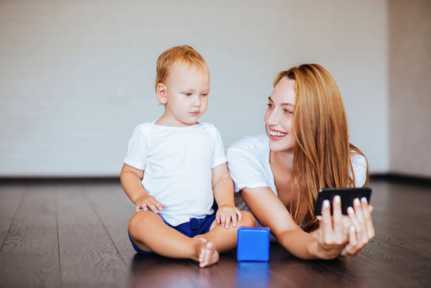 Happy mother with son and smartphone, self shoot - Valokuva, kuva