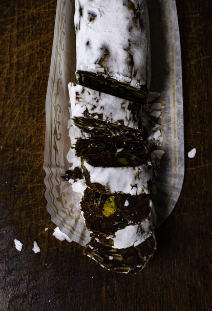 Chocolate salami on wooden background, with nuts - Photo, Image