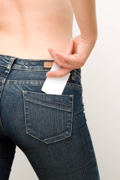 crop photo of woman wearing jeans holding blank white credit card in hand - Fotoğraf, Görsel