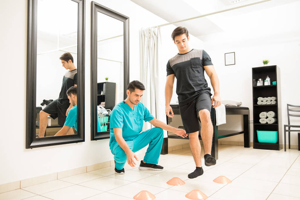 Fyzioterapeut, motivování pro muže chodit mezi kužely v nemocnici - Fotografie, Obrázek