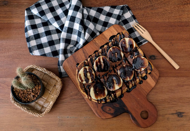 Tepesinde dilimlenmiş muz, fındık, çikolata ve karamel şurup ile tost - Fotoğraf, Görsel