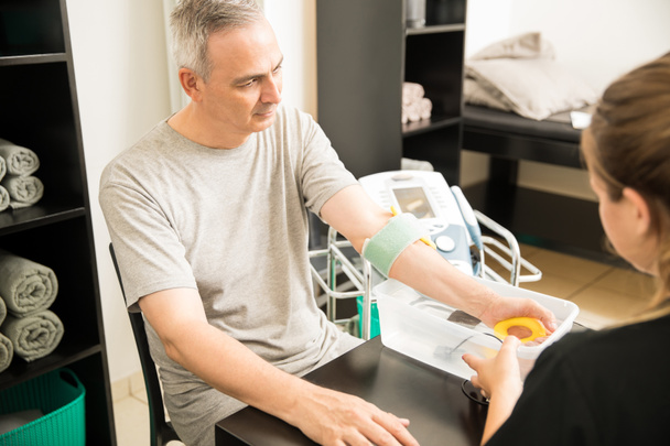 Starší muž přijímá elektroterapie od terapeut v nemocnici - Fotografie, Obrázek