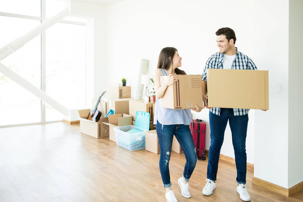 Full length of happy couple looking at each other while setting up new home - Photo, Image