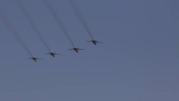 Αρκετές στρατιωτικές μαχητές πετούν σε σχηματισμό ενάντια στον γαλάζιο ουρανό. - Φωτογραφία, εικόνα