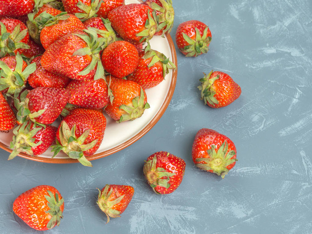 frisch gepflückte rote Erdbeeren auf einem Teller liegend - Foto, Bild