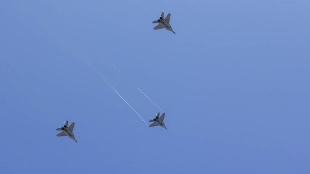 Varios combatientes militares están volando en una formación contra el cielo azul
. - Foto, imagen