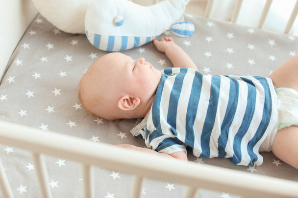Cute little baby lying in crib. Sleeping time - Fotografie, Obrázek